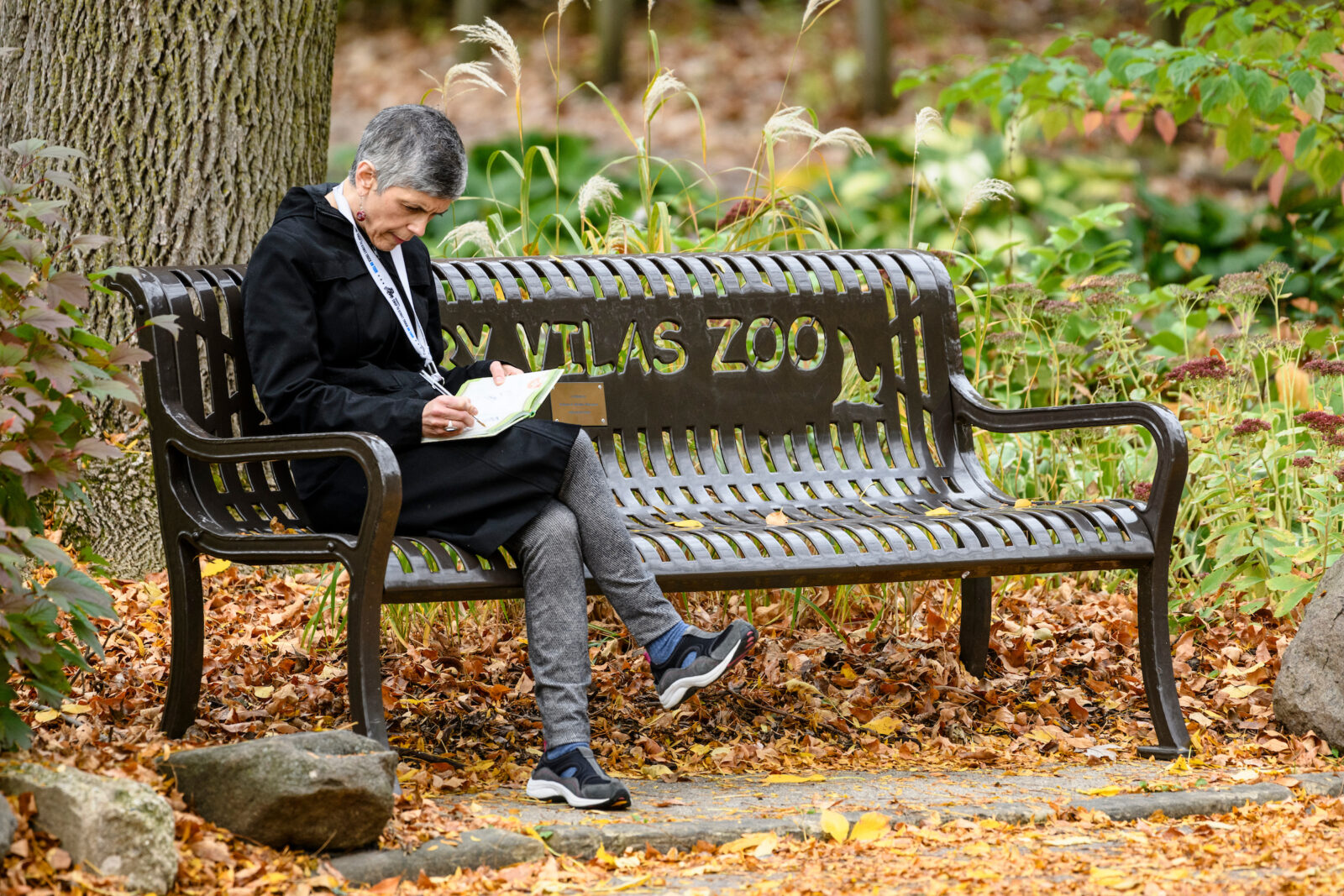 A visitor relaxes on a sitting bench at the Henry Vilas Zoo