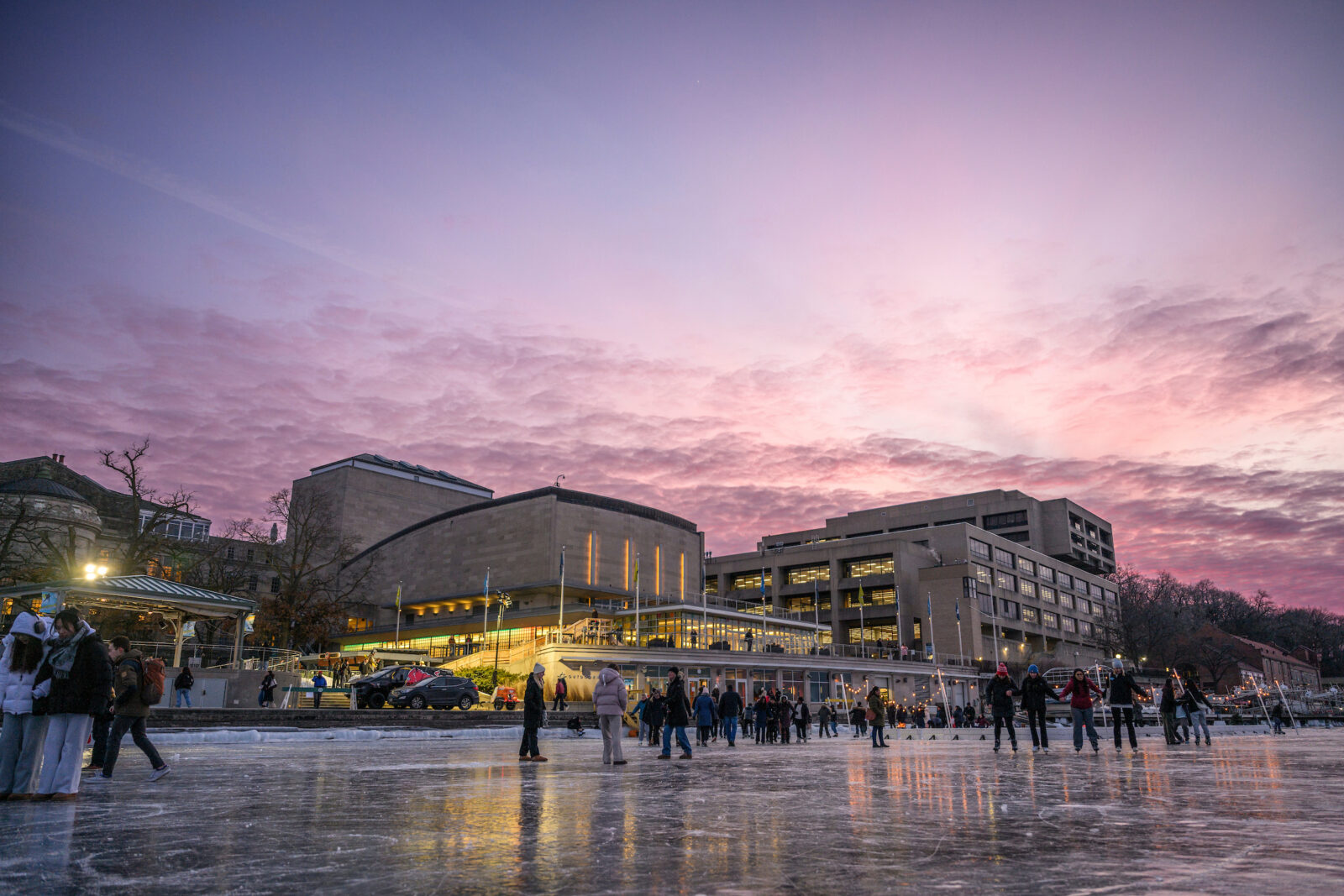 People walk, slide, and skate on frozen Lake Mendota near the Memorial Union during the annual Wisconsin Union Winter Carnival