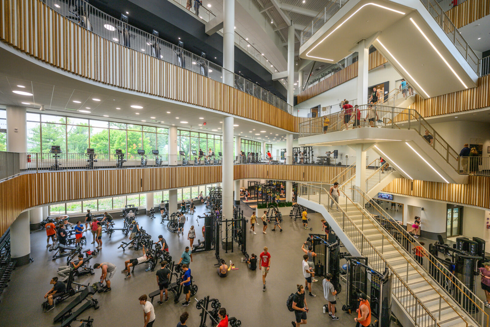 The fitness space on the first floor is bustling with people using strength equipment while the second and third floors have cardio equipment with a view of Lake Mendota at the Bakke Recreation & Wellbeing Center at the University of Wisconsin–Madison on Sept. 22, 2023. (Photo by Althea Dotzour / UW–Madison)