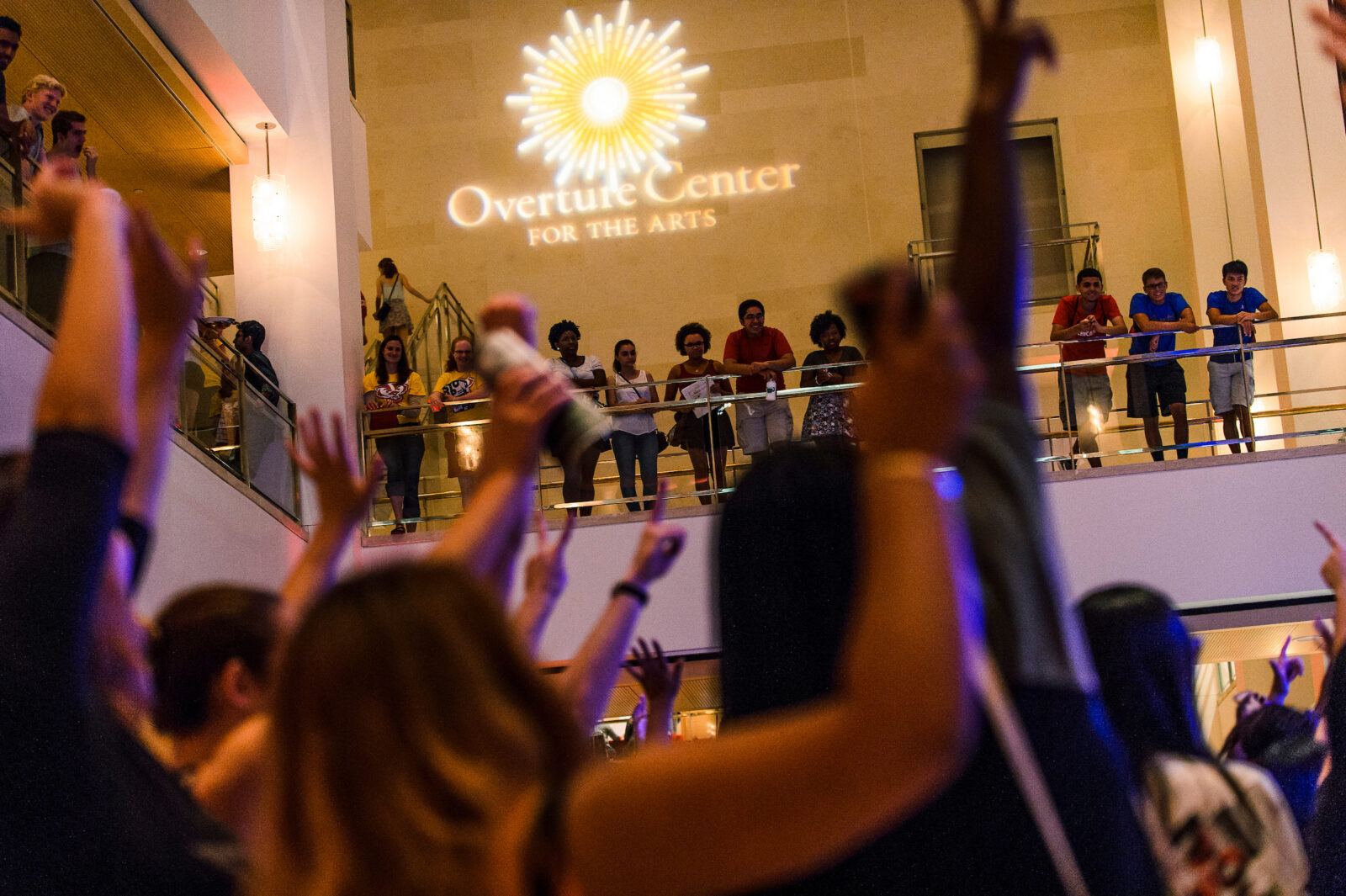 During a Wisconsin Welcome event dubbed First Night at the Overture, University of Wisconsin-Madison students cheer a live band karaoke performance at the Overture Center for the Arts in downtown Madison on Sept. 4, 2015. Throughout the evening, several thousand freshmen and transfer students filled multiple spaces at Overture and enjoyed a variety of arts, comedy, dance and music performances, plus socializing with new friends. The event is organized by the Center for the First-Year Experience (CFYE). (Photo by Jeff Miller/UW-Madison)