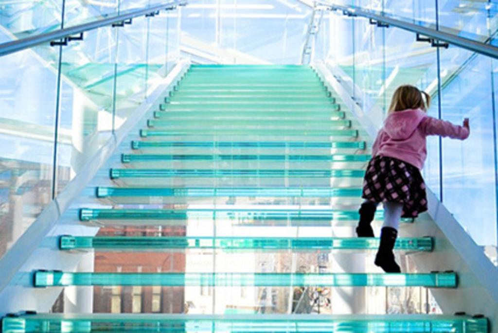 A child walking up the glass steps