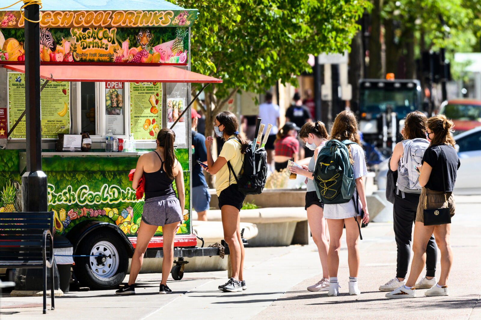 Wearing face masks, pedestrians and students purchase drinks and food from a food cart vendor on Library Mall at the University of Wisconsin-Madison during the first day of classes on Sept. 2, 2020. Adhering to Smart Restart safety protocols that include wearing of masks and physical distancing, the UW-Madison campus is reopening for the Fall 2020 semester during the global coronavirus (COVID-19) global pandemic. (Photo by Jeff Miller / UW-Madison